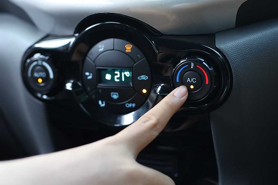 Finger pressing on Power button on off switch of a Car air conditioning and heating system To turn on the Fan of the AC inside the Car. auto climate control